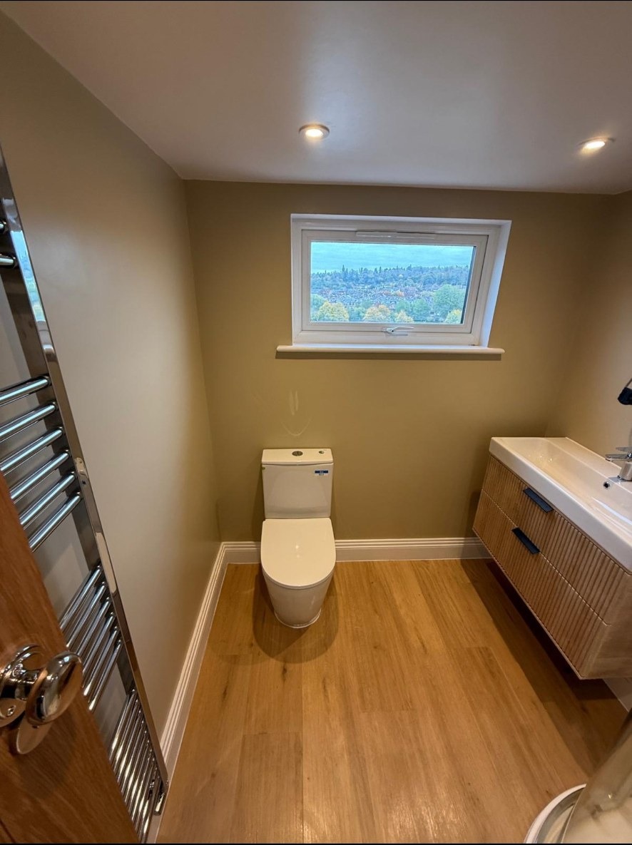 Warm oak and a floating fluted vanity.